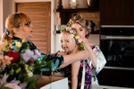 Little girl with a flower crown being tied on by her bride mum. photo by Charlotte Boswell