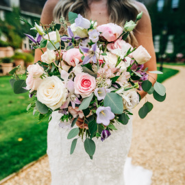 pinks lilacs and white wedding flowers in an abundant bouquet