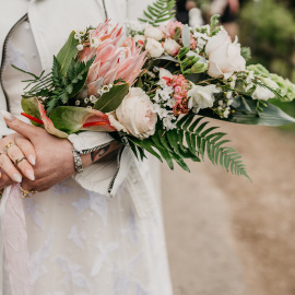 side held bouquet to lay upon your arm in unusual and exotic flowers anthurium and protea